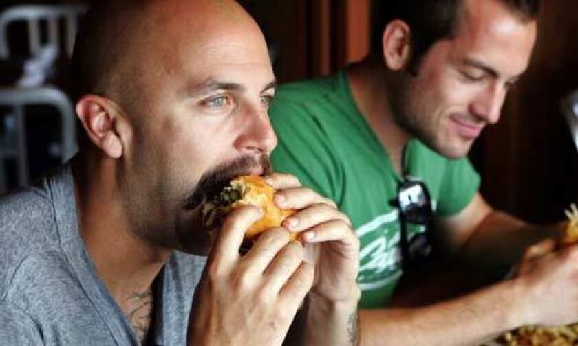 A diner enjoys a burger during lunch at 8 oz. Burger Bar in Hollywood.