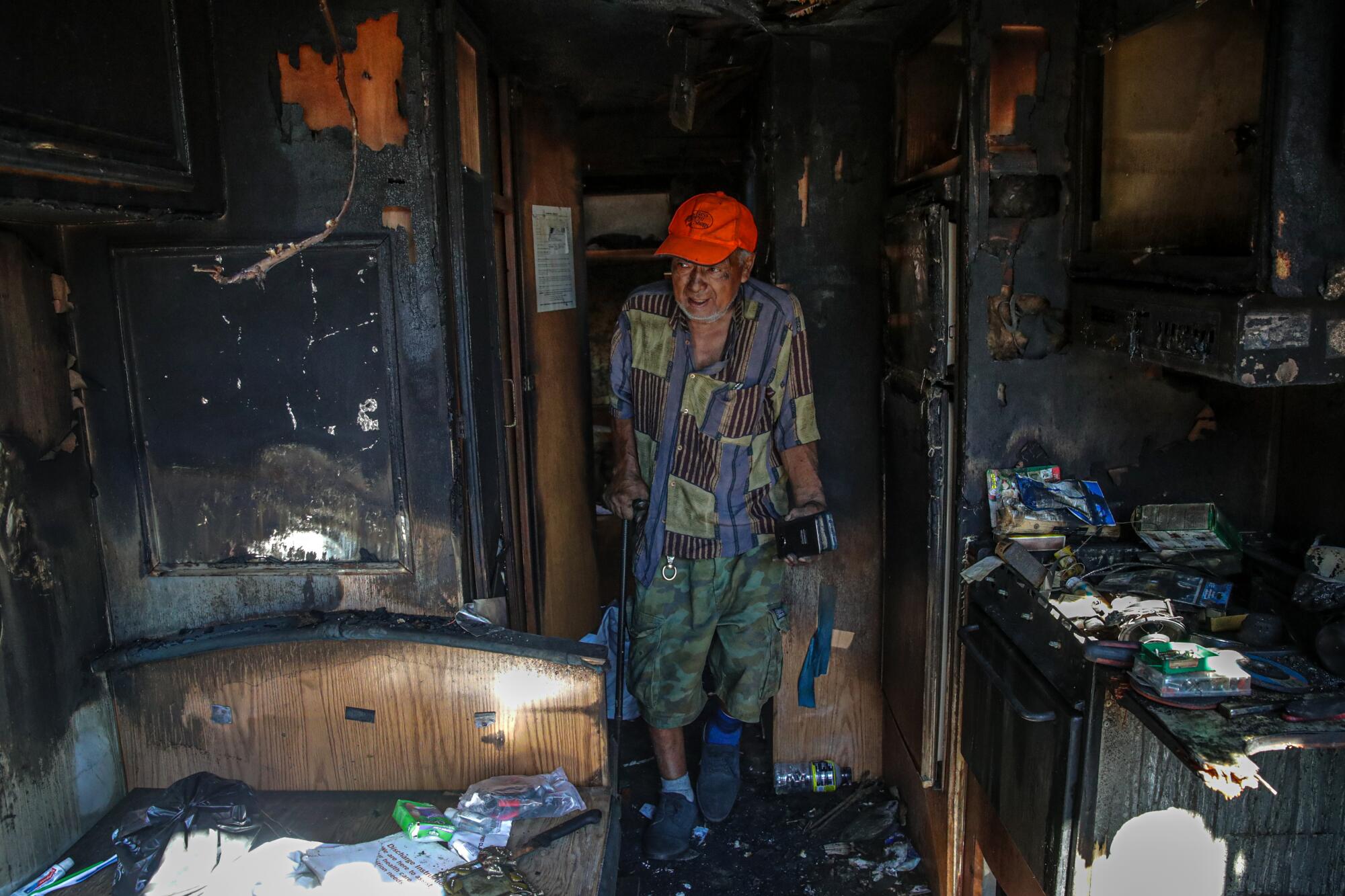 A person stands in a charred room.