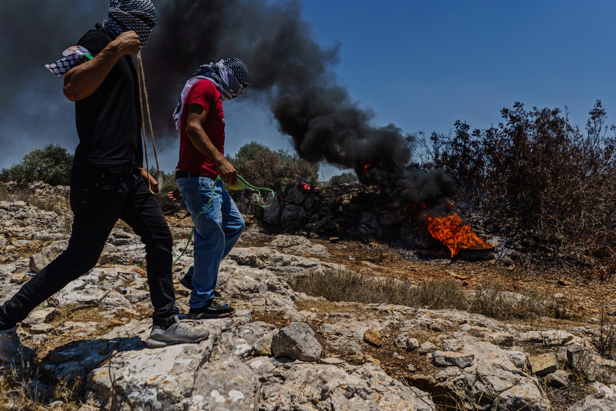Smoke rises from a fire as Palestinians protest against West Bank Jewish settlement 