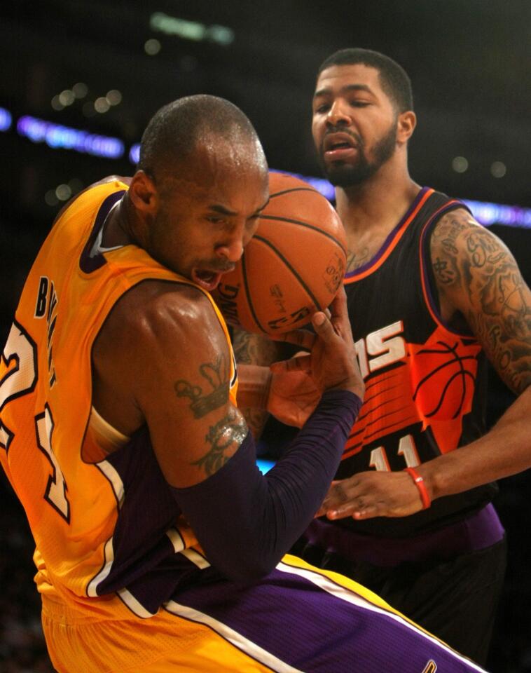 Kobe Bryant loses control of the ball as Phoenix forward Markleff Morris stands over him.