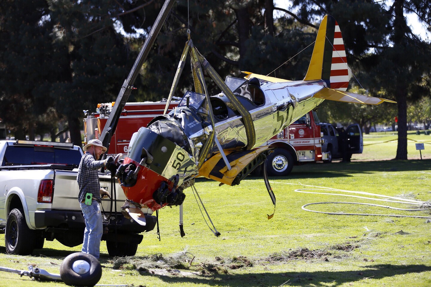 Workers move the vintage plane that crashed on the Penmar golf course not far from Santa Monica Municipal Airport.