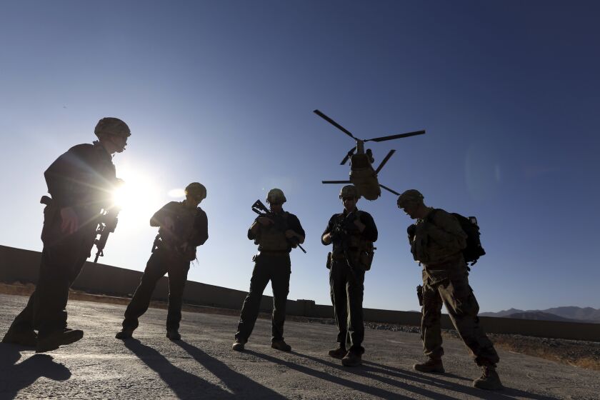 FILE - In this Nov. 30, 2017 file photo, American soldiers wait on the tarmac in Logar province, Afghanistan. Top officials in the White House were aware in early 2019 of classified intelligence indicating Russia was secretly offering bounties to the Taliban for the deaths of Americans, a full year earlier than has been previously reported. (AP Photo/Rahmat Gul, File)