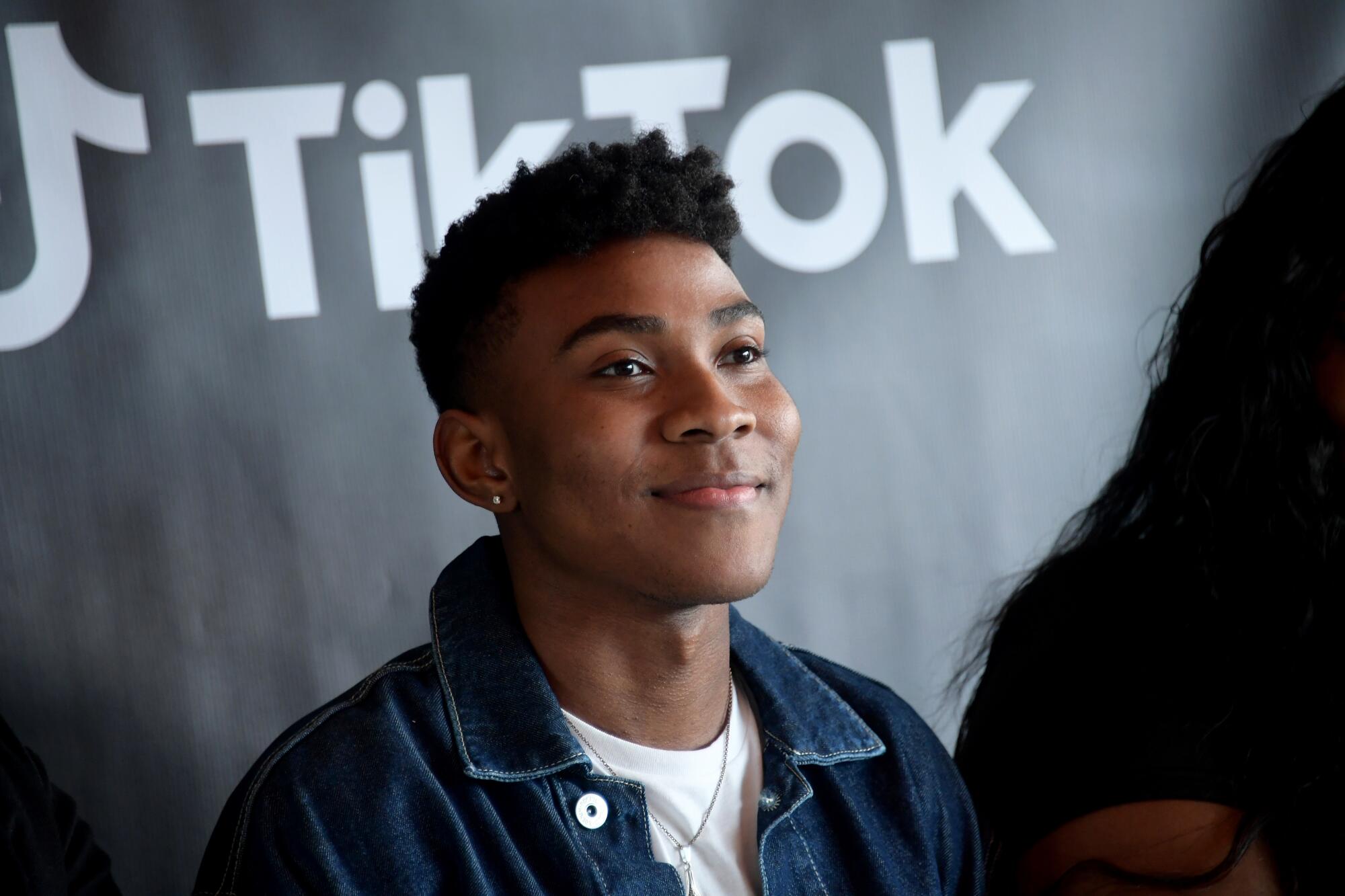Kahlil Greene smiling in three-quarter profile against a black background with the TikTok logo in white type