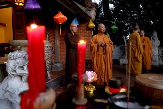 SANTA ANA, CA - MAY 17: Buddhist monks Quang Hieu, far left, of the Bat Nha Temple in Santa Ana, and Thich Vien Huy, center, of the Dieu Ngu Temple in Westminster, before the start of a candlelight vigil at the Viet Heritage House & Garden on Tuesday, May 17, 2022 in Santa Ana, CA. Orange County faith leaders -- including Buddhist monks and Catholic priests -- will hold a candlelight vigil to mark the 1 million lives lost in the coronavirus pandemic, as well as the victims of the shootings in Buffalo and Laguna Woods. (Gary Coronado / Los Angeles Times)