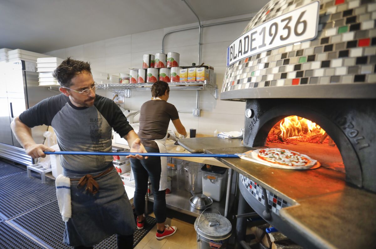 John Carlo Ferraiuolo, general manager and partner at the new Italian restaurant Blade 1936 in Oceanside, in the original Blade-Tribune and News building makes a Margherita pizza.Photographed September 24, 2019, in Oceanside, California.