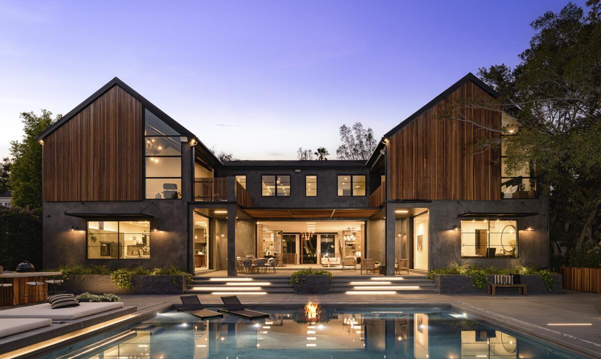 This photo shows a two-story home with a pool in the foreground.