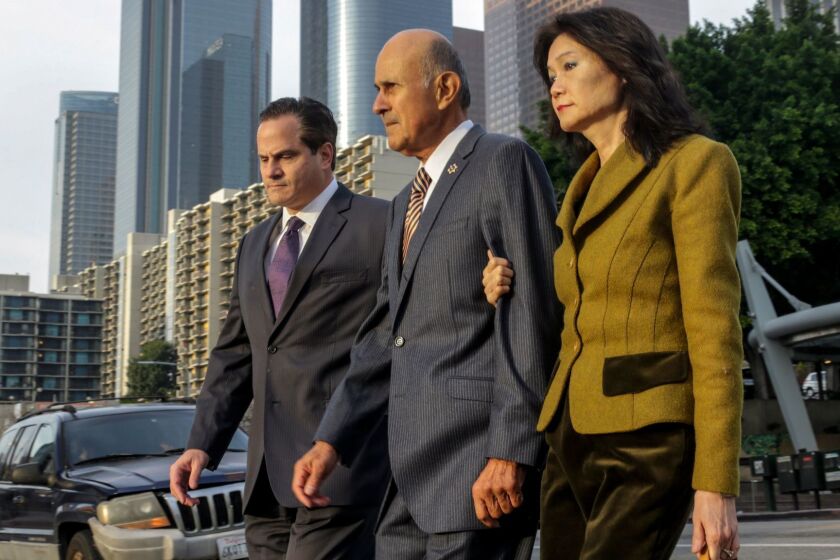 Former Los Angeles County Sheriff Lee Baca, center, flanked by his attorney Nathan J. Hochman, left, and wife Carol Chiang, arrives at federal court.