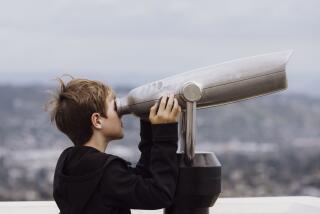 Los Angeles, CA - March 15: Andrew Mackno, 10, looks into a pair of binoculars at the Griffith Observatory on Friday, March 15, 2024 in Los Angeles, CA. (Carlin Stiehl / For The Times)