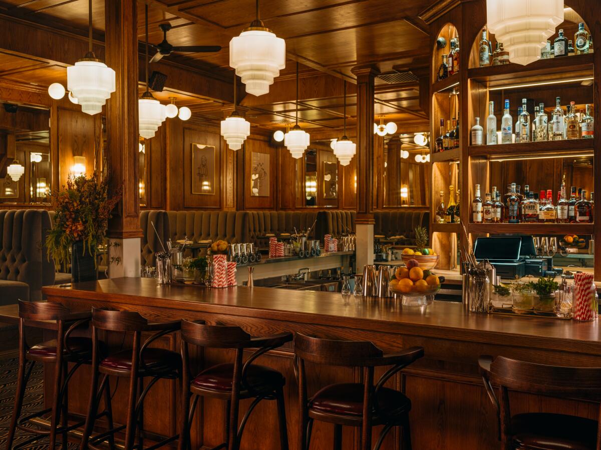 Inside a restaurant with wood paneling, old-fashioned light fixtures and wood seating