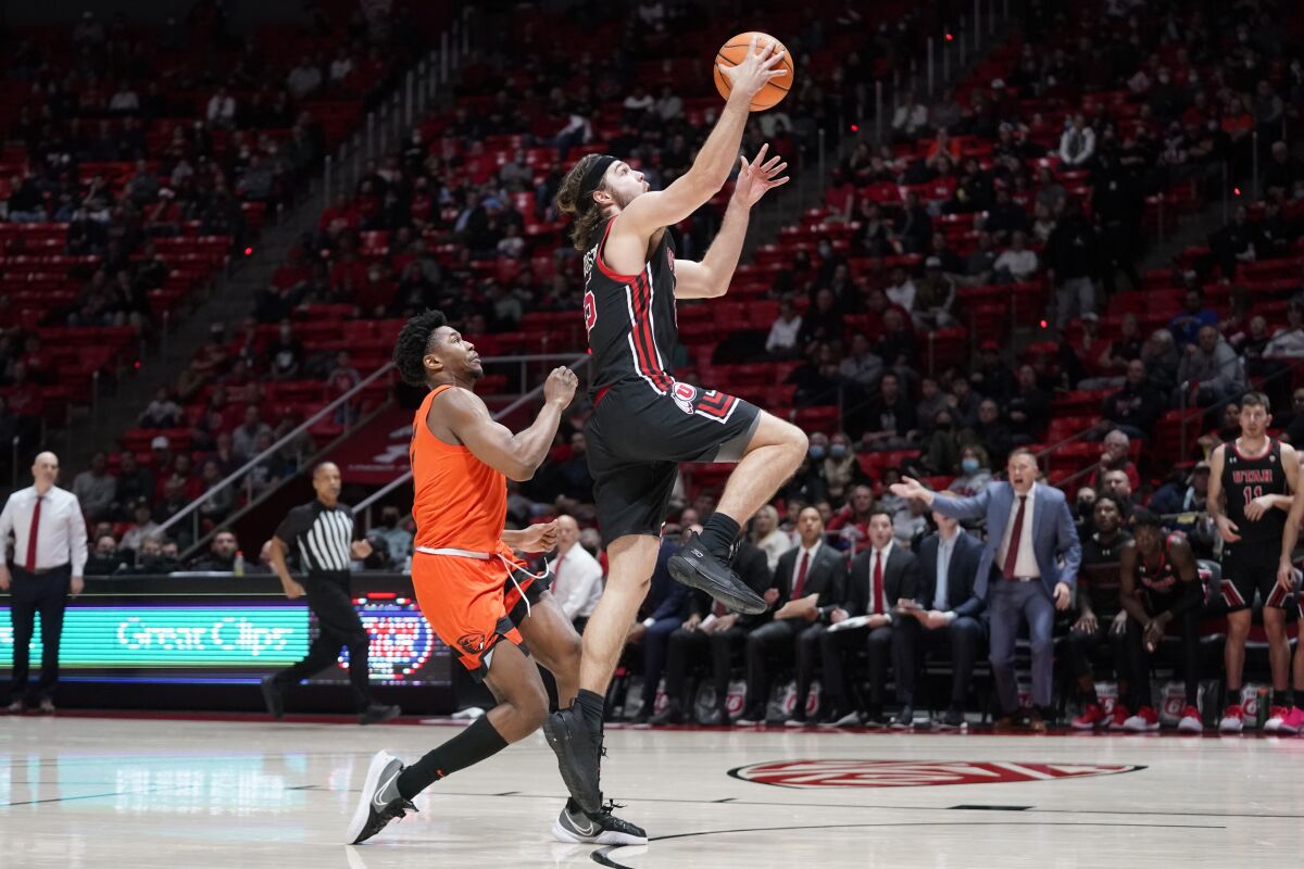 Utah guard Rollie Worster, right, goes to the basket as Oregon State guard Dexter Akanno defends during the second half of an NCAA college basketball game Thursday, Feb. 3, 2022, in Salt Lake City. (AP Photo/Rick Bowmer)