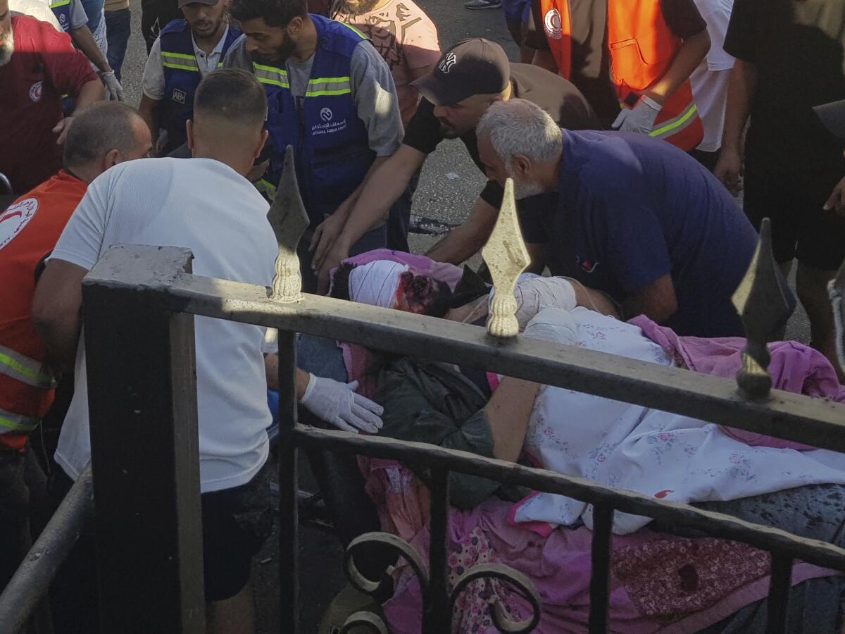 People huddle over a man with a bandaged head.