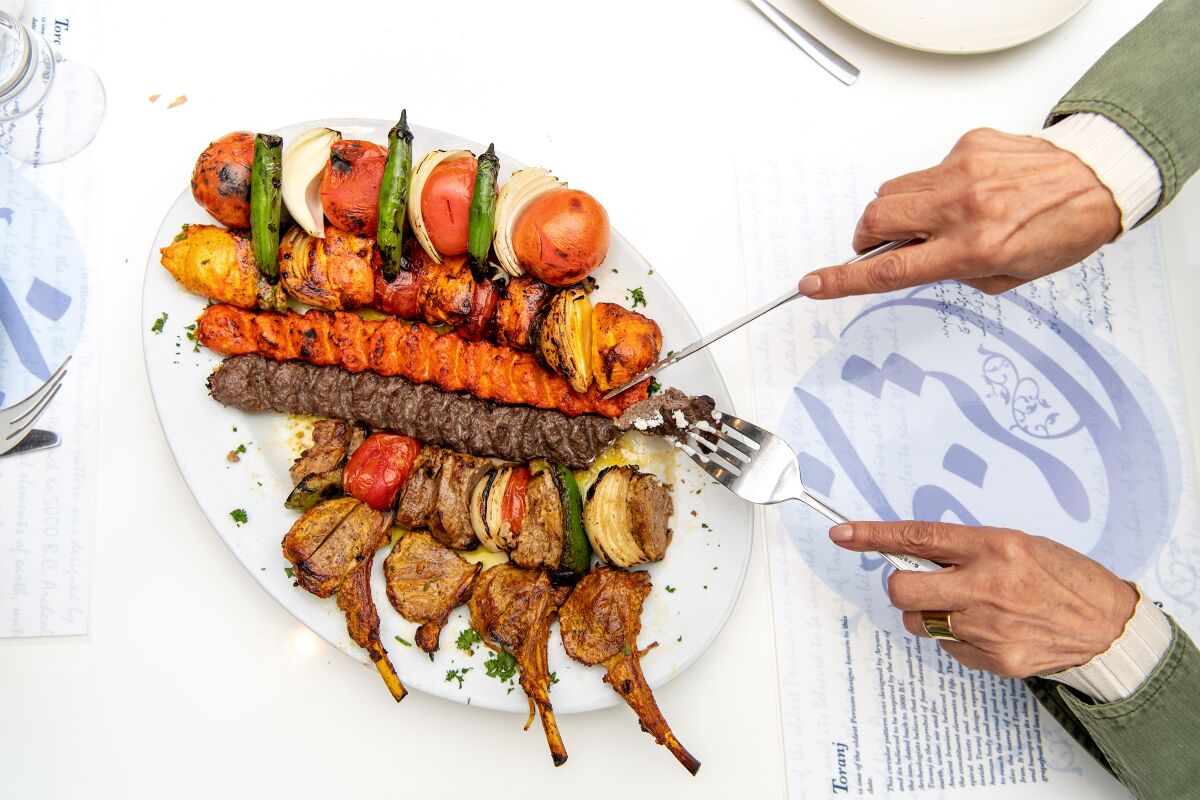 A kabob combination plate that includes chicken, chicken koobideh, beef koobideh, filet mignon barg and lamb chops 