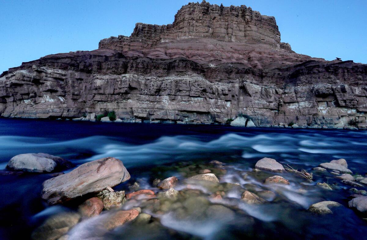 A mesa rises behind a stretch of the Colorado River, Navajo Nation.