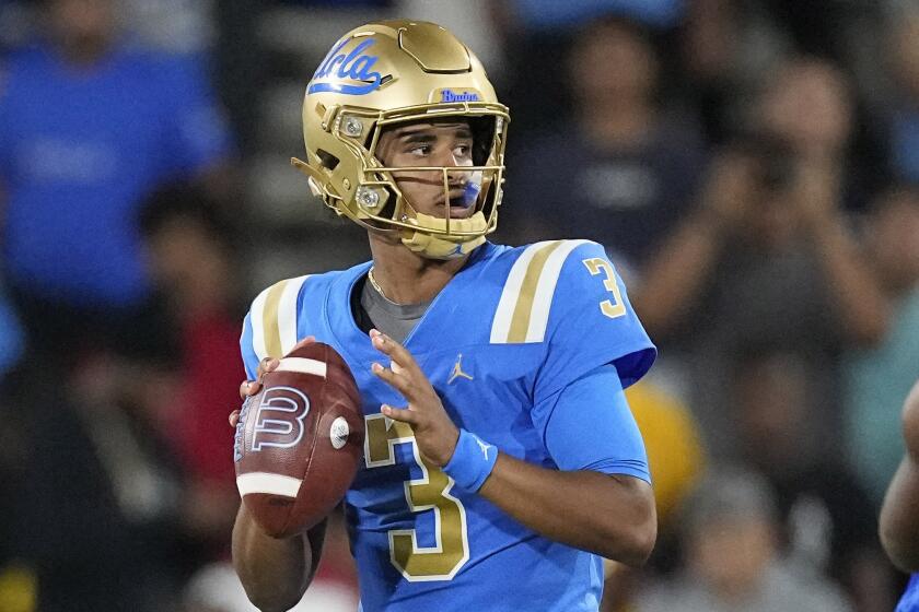 UCLA quarterback Dante Moore scans the field and gets set to pass during a game