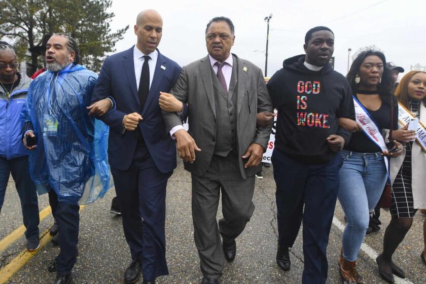 U.S. Sen. Cory Booker, D-N.J., third from left, and the Rev. Jesse Jackson march to cross the Edmund Pettus Bridge Sunday, March 3, 2019, during the Bloody Sunday commemoration in Selma, Ala. The infamous ?Bloody Sunday? on March 7, 1965, galvanized support for the passage of the Voting Rights Act that year. (AP Photo/Julie Bennett)