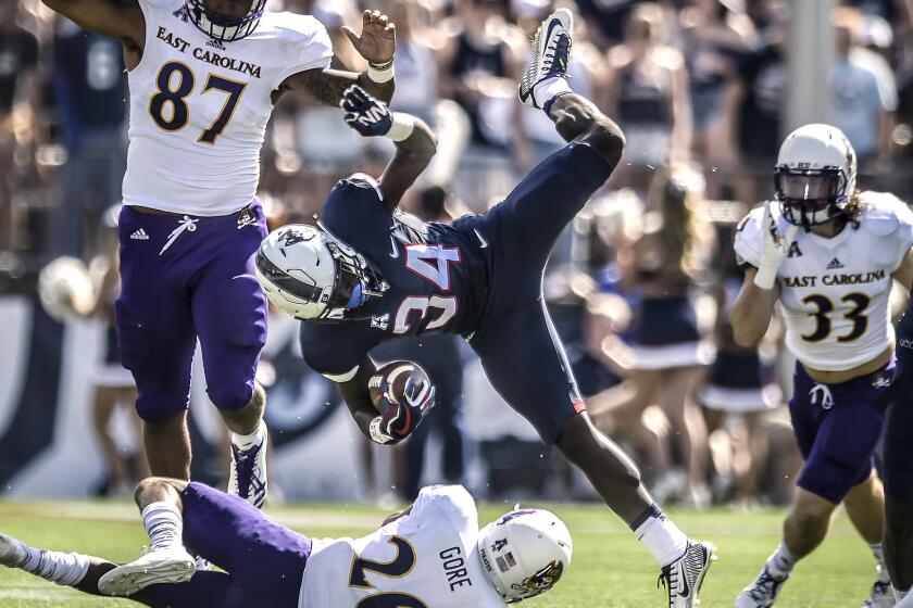 East Carolina defenders, from left, Gaelin Elmore, Colby Gore and Cannon Gibbs, swarm to Kevin Mensah of UConn during the first period at Rentschler Field in East Hartford, Conn., on Sunday, Sept. 24, 2017. East Carolina won, 41-38. (Mark Mirko/Hartford Courant/TNS) ** OUTS - ELSENT, FPG, TCN - OUTS **