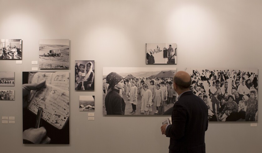 A visitor looks at photographs displayed during an exhibition organised by The United Nations Relief and Works Agency.