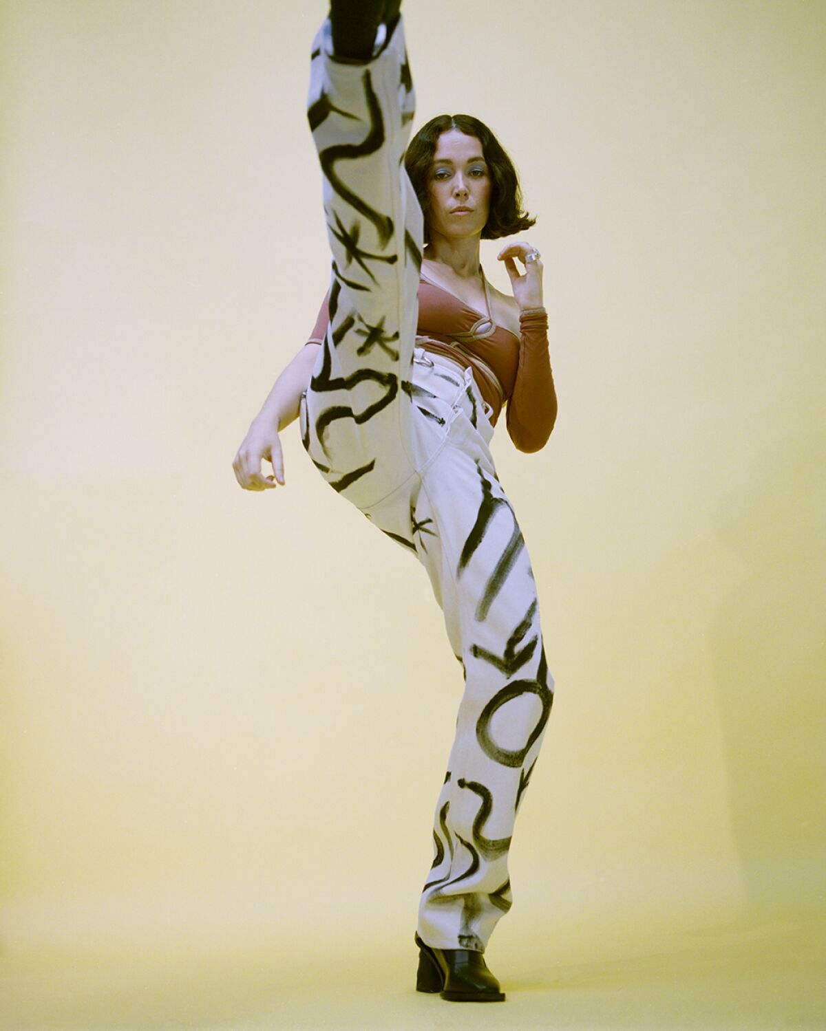 Kelly Lee Owens kicking one leg in the air