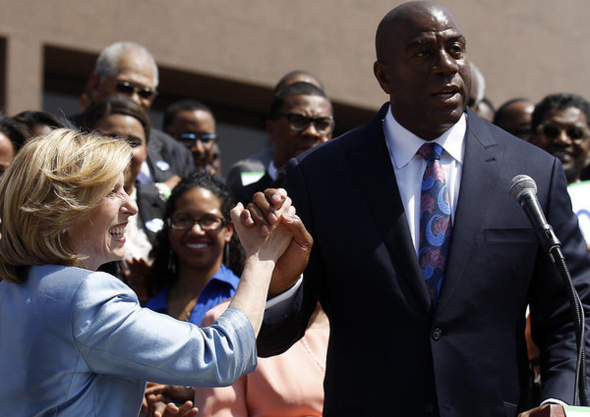 Former Lakers great and current Dodgers executive Magic Johnson gives Wendy Greuel a high five after endorsing her campaign to be mayor of Los Angeles.