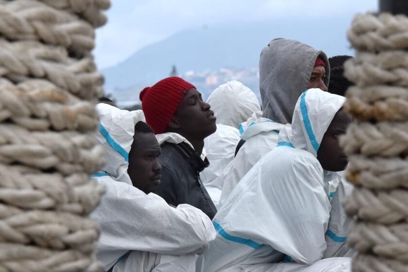 Men wait to disembark from the Italian coast guard vessel Dattilo following a rescue operation of migrants and refugees at sea, on Feb. 1, 2016 in Messina, Sicily. Over 10,000 unaccompanied migrant children have disappeared in Europe, the EU police agency Europol said yesterday.