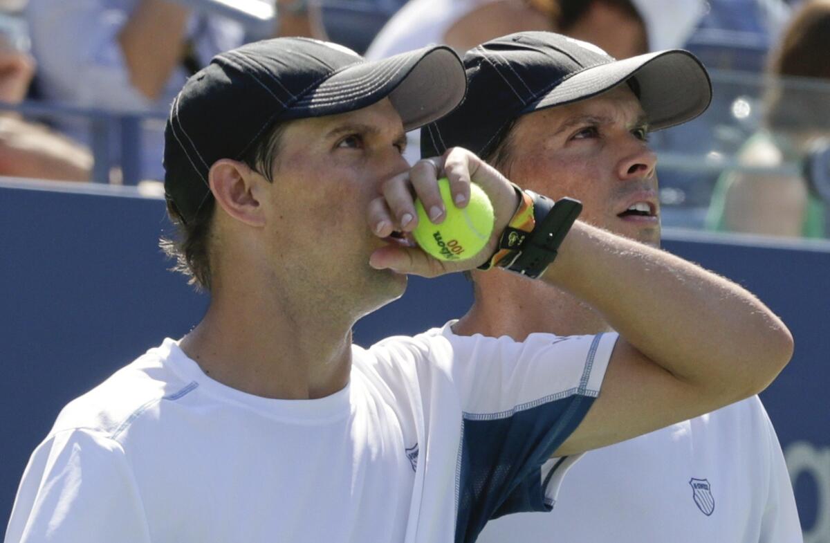 Mike, left, and Bob Bryan watch a replay on a screen during a semifinal doubles match against Scott Lipsky and Rajeev Ram on Thursday at the U.S. Open.