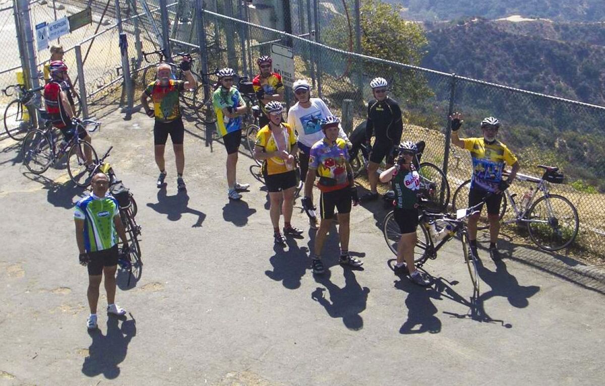 Bisikletli bir çitin yanında toplanan insanların yukarıdan çekilmiş fotoğrafı 