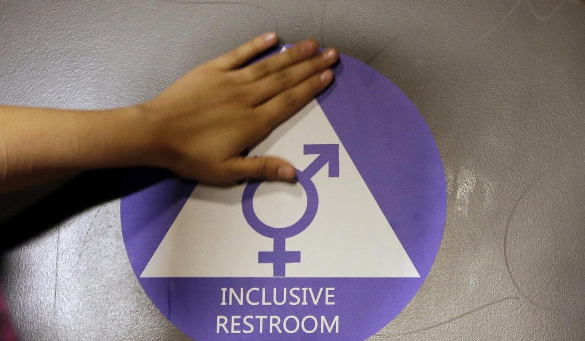 A new sticker is placed on the door at the ceremonial opening of a gender neutral bathroom at Nathan Hale High School in Seattle, in this file photo taken May 17, 2016.