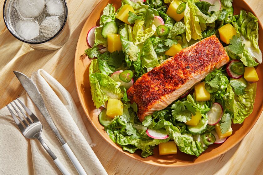 Spiced salmon on a bed of greens with mango and fresh peppers.
