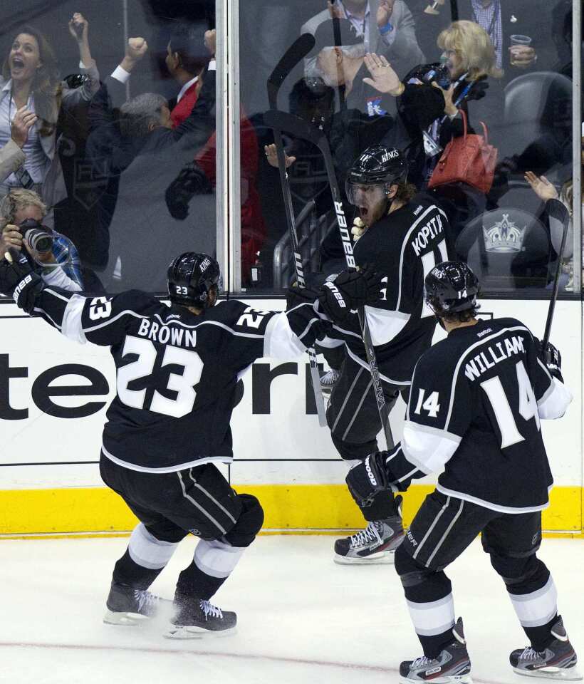 Kings forward Anze Kopitar, center, is congratulated by teammates Dustin Brown, left, and Justin Williams after scoring during the second period of the Kings' 4-0 victory over the New Jersey Devils in Game 3 of the Stanley Cup Final at Staples Center.
