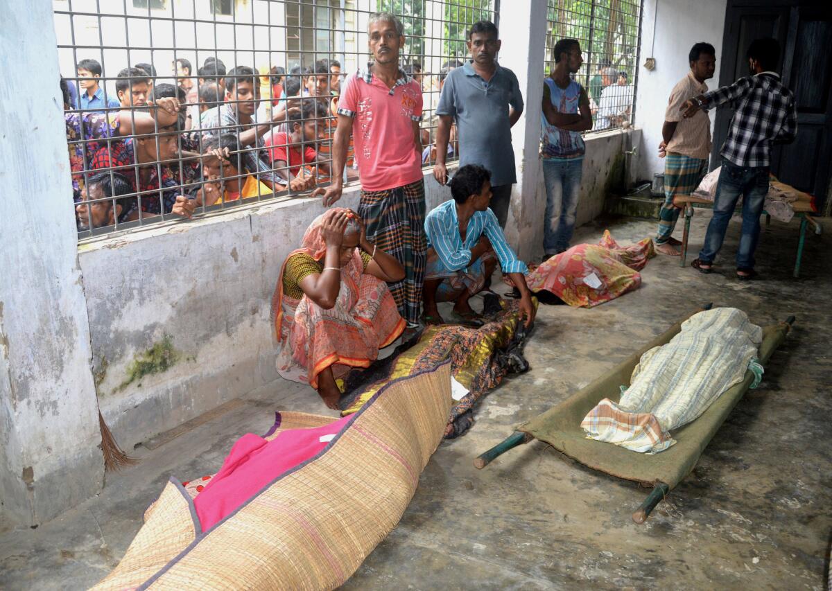 Una anciana llora junto a cadáveres en el Hospital de Mymensingh, 115 kilómetros (70 millas) al norte de Dhaka, Bangladesh, el viernes 10 de julio de 2015. Decenas de personas murieron el viernes en una estampida cuando cientos de personas irrumpieron en la casa de un empresario local para un acto benéfico durante el mes sagrado musulmán del Ramadán. (Foto AP/Jahangir Kabir Jewel)