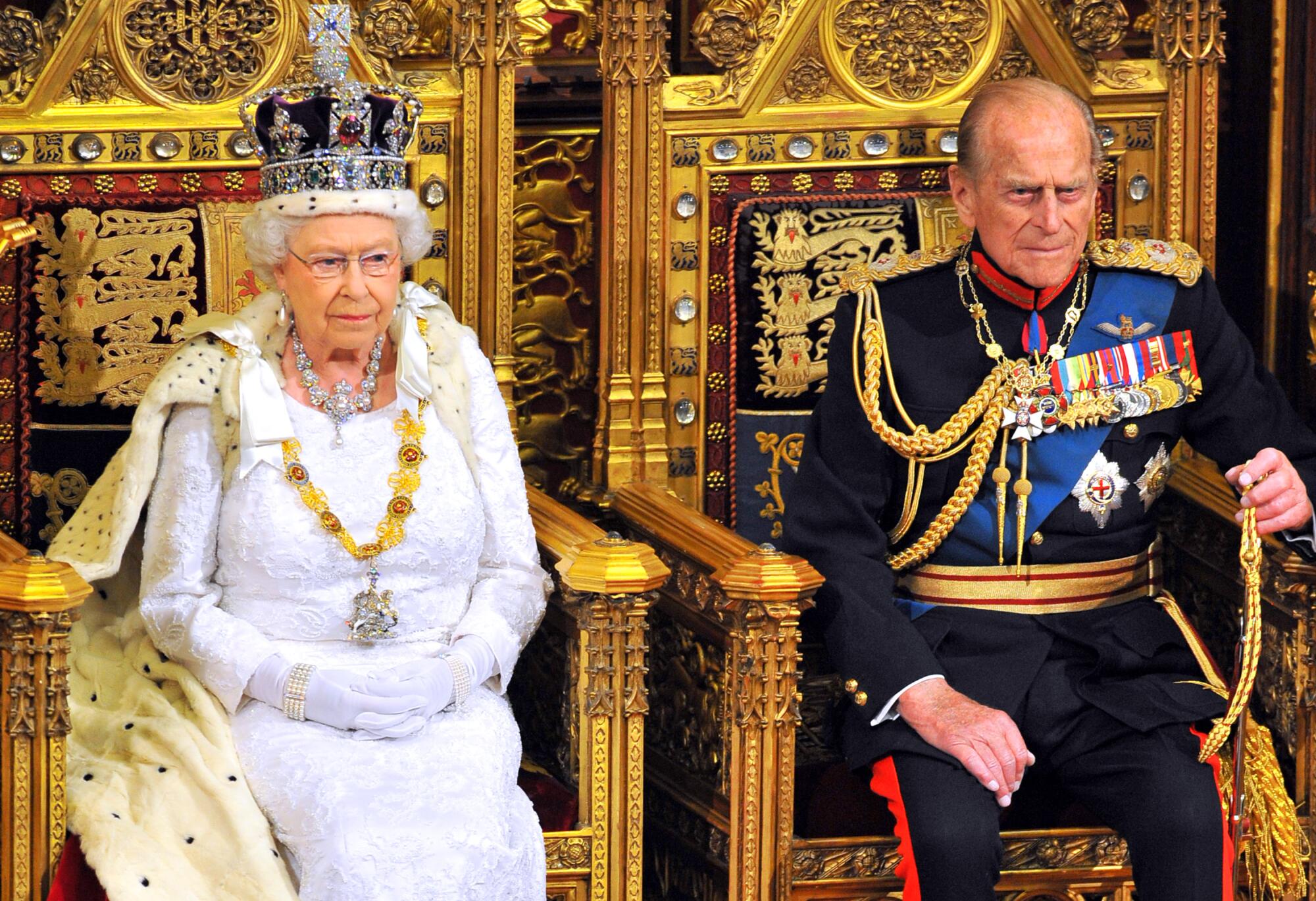 Queen Elizabeth II sits with Prince Philip, Duke of Edinburgh as she delivers her speech