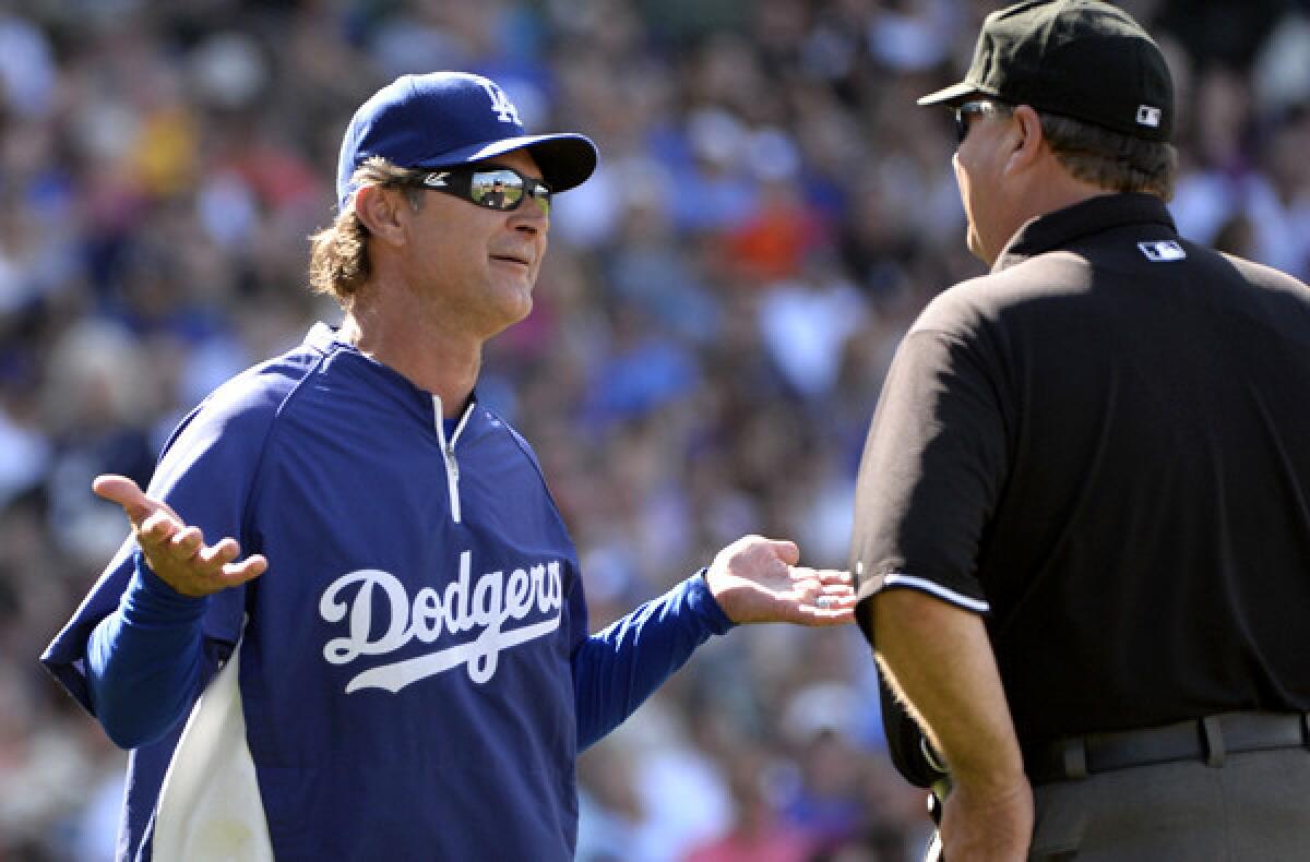 Dodgers Manager Don Mattingly discusses a call with first base umpire Jerry Layne after he reversed a call on a fly ball hit by Cubs pitcher Jeff Samardzija in the third inning Saturday.