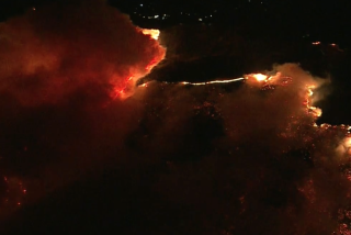 A fast-moving fire burns early Tuesday morning in Malibu.