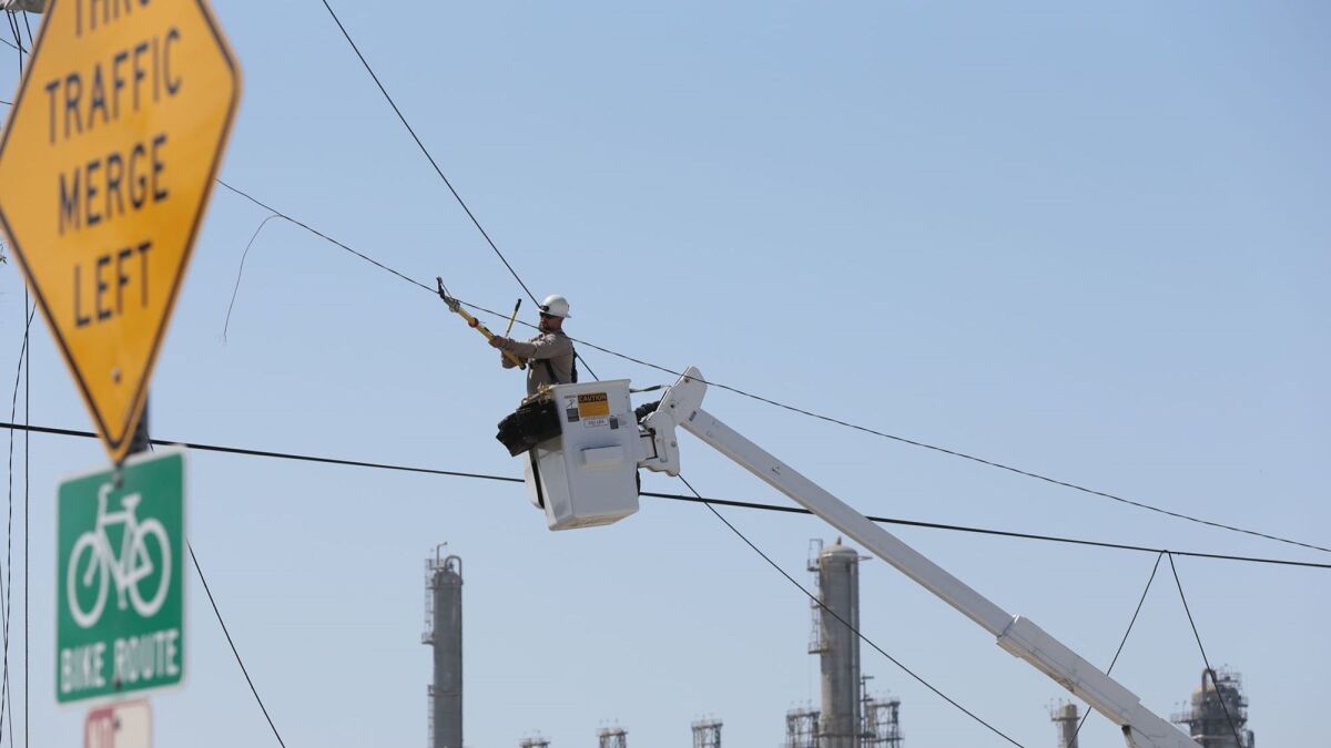A Southern California Edison employee repairs a power line in 2013. The utility this week was fined $8 million by the California Public Utilities Commission in connection to an incident that injured three Marines in Twentynine Palms in 2015.