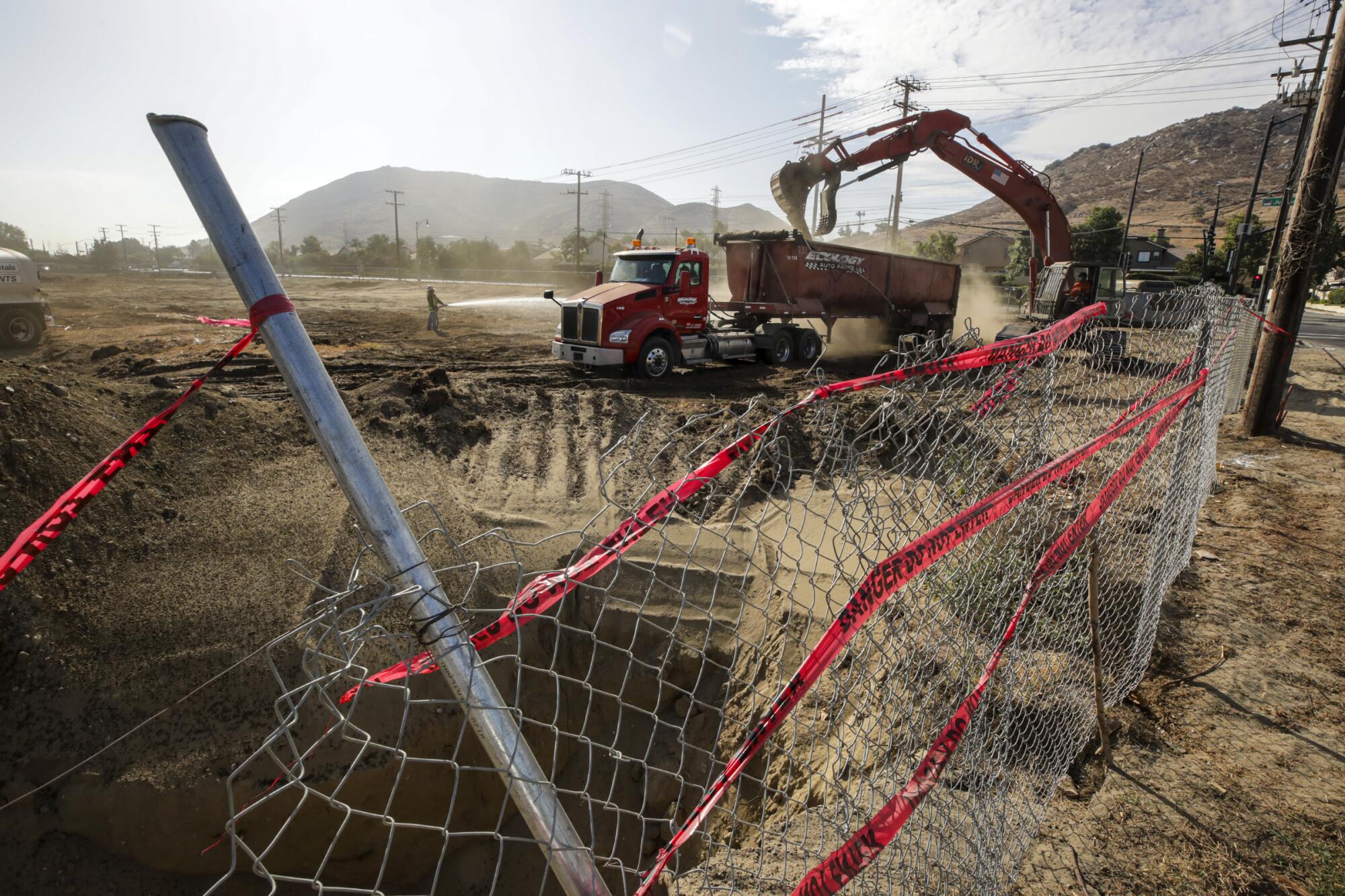 Construction vehicles are seen near a hole dug at a worksite