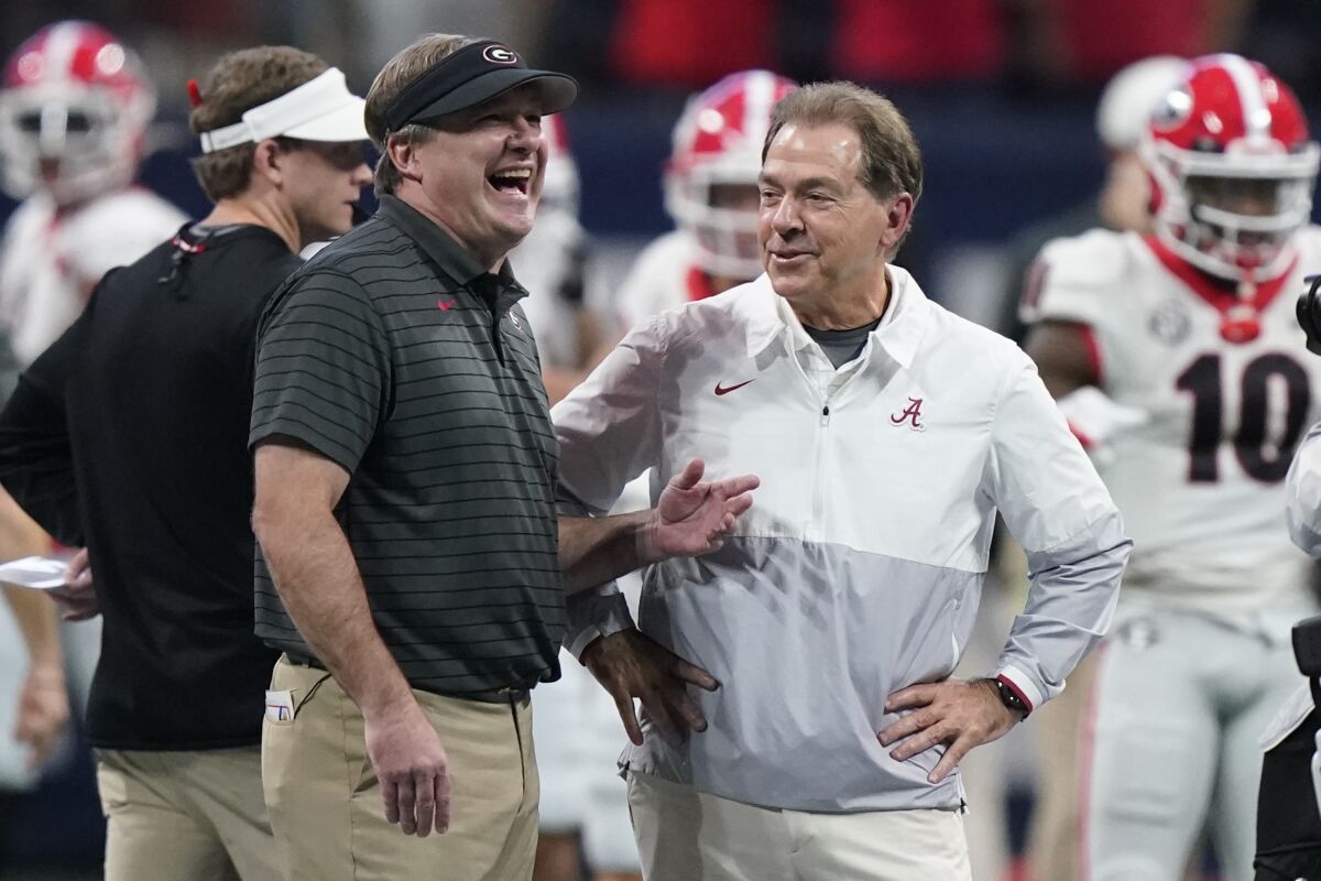 FILE - Georgia head coach Kirby Smart speaks with Alabama head coach Nick Saban before the first half of the Southeastern Conference championship NCAA college football game, Saturday, Dec. 4, 2021, in Atlanta. Georgia plays Alabama in the College Football Playoff national championship game on Jan. 10, 2022. (AP Photo/Brynn Anderson, File)
