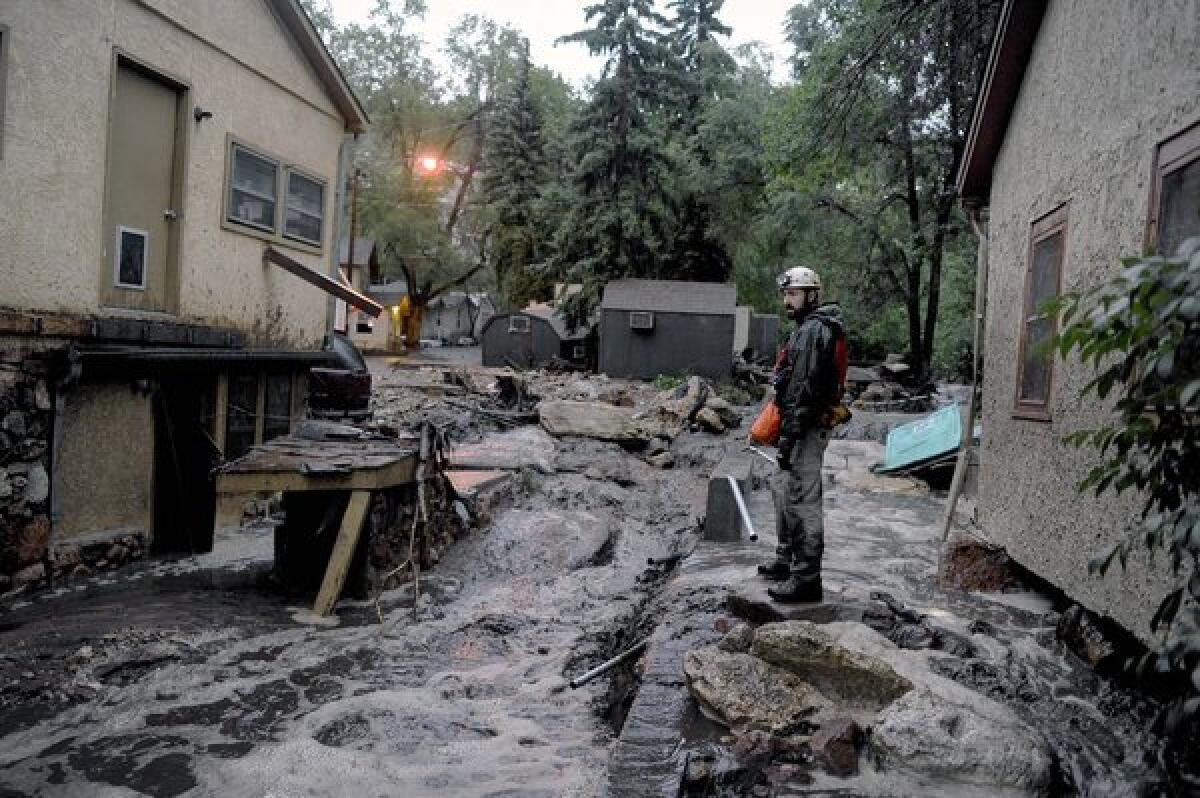 Volunteer rescuer Jesse Rochette searches the Fountain Creek flood waters for anyone trapped or stranded as another flash flood washes off the Waldo Canyon burn scar in Manitou, Colo.