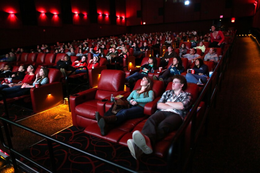 Kerri Donaghue, left, and Jack Hennessy relax in recliner seats at AMC Movie Theater in Braintree, Mass.