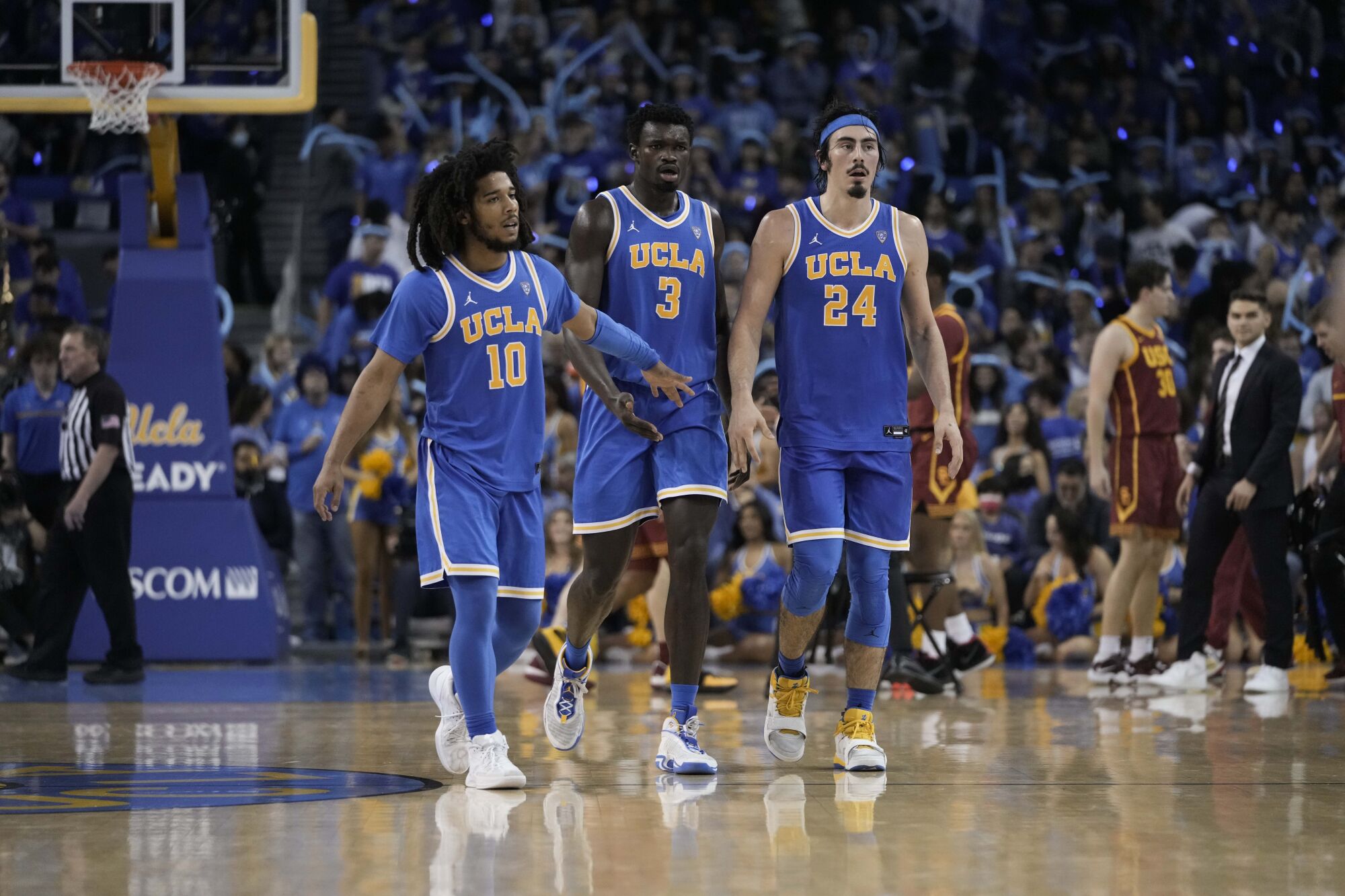 UCLA's Tyger Campbell, Adem Bona and Jaime Jaquez Jr. walk on the court during the second half against USC.