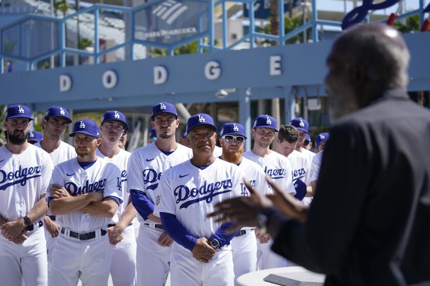 Los Dodgers de Los Ángeles escuchan a David Robinson, hijo de Jackie Robinson, quien pronuncia un discurso el viernes 15 de abril de 2022 (AP Foto/Ashley Landis)
