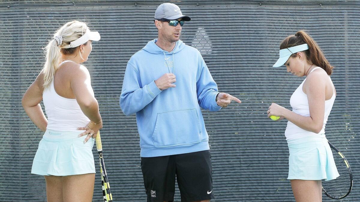 Corona del Mar High coach Jamie Gresh talks with his doubles team of Kristina Evloeva, left, and Roxy MacKenzie, right, in the CIF Southern Section Individuals quarterfinal match against Palos Verdes at Seal Beach Tennis Center on Wednesday.