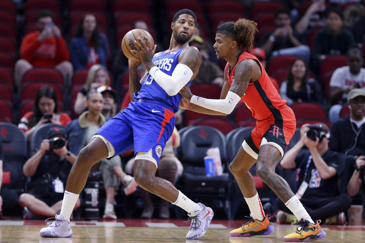 Clippers guard Paul George leans back into Houston Rockets guard Jalen Green.