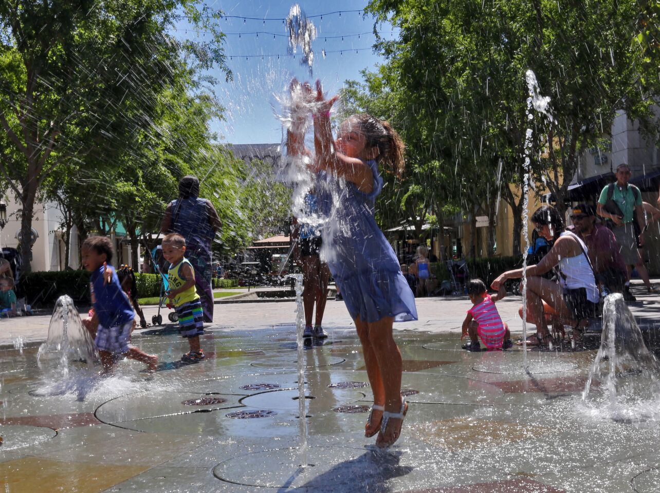 Angela Robles, 3, enjoys a water shooting fountain at Victoria Gardens on a hot afternoon in Rancho Cucamonga.