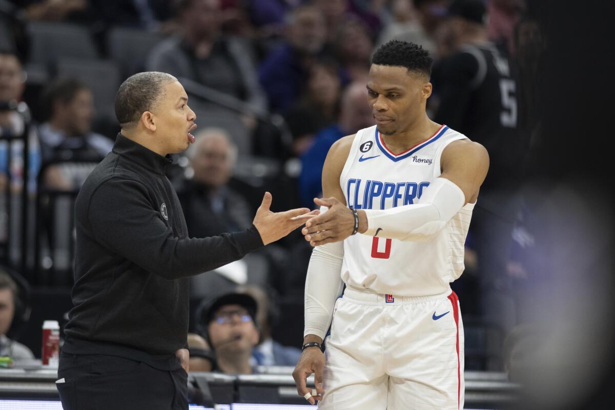 Clippers guard Russell Westbrook, right, slaps hands with coach Tyron Lue.