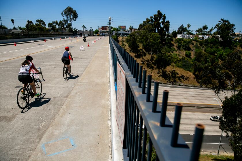 Cyclists ride along Adams Avenue across Interstate 805 on what has been designated a "slow street," meaning it's been modified to make room for cyclists and pedestrians to socially distance, on May 4, 2020 in San Diego, California.