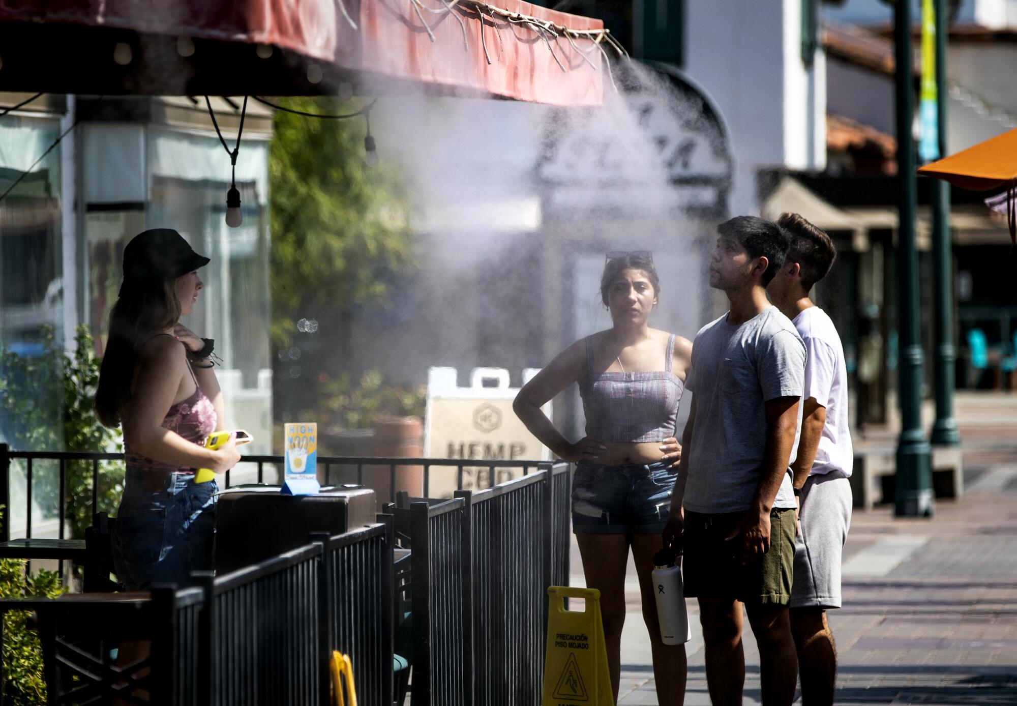 Customers cool off at a downtown restaurant mister in Palm Springs.