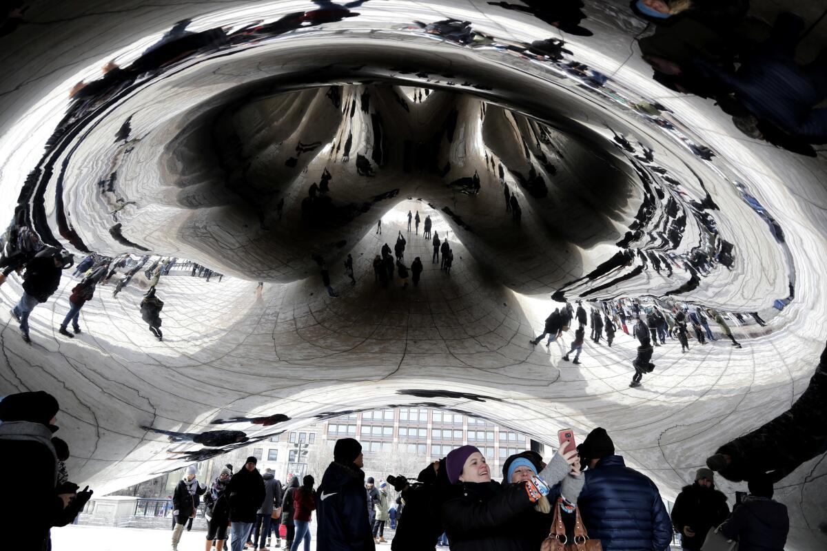 People have bundled up against the cold at the Cloud Gate at Millennium Park in Chicago on Sunday.