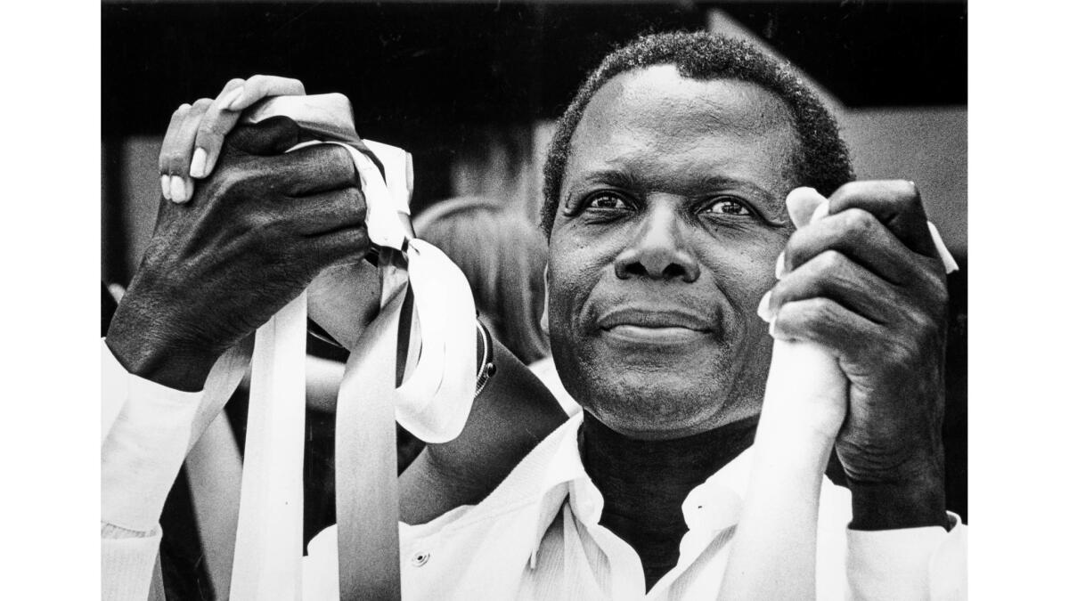 May 25, 1986: Actor Sidney Poitier participates in a Hands Across America event on Wilshire Boulevard in Beverly Hills.