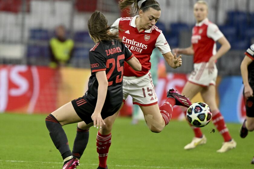 Bayern's Sarah Zadrazil, left, and Arsenal's Katie McCabe battle for the ball during the women's Champions League first leg quarterfinal soccer match between Bayern Munich and Arsenal at Allianz Arena, Munich, Germany, Tuesday March 21, 2023. (Peter Kneffel/dpa via AP)
