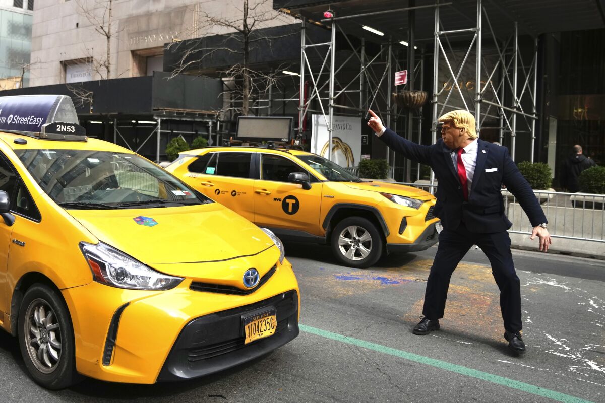 Neil Greenfield impersonates former President Donald Trump in front of Trump Tower on Wednesday, March 22, 2023, in New York. (AP Photo/Bryan Woolston)